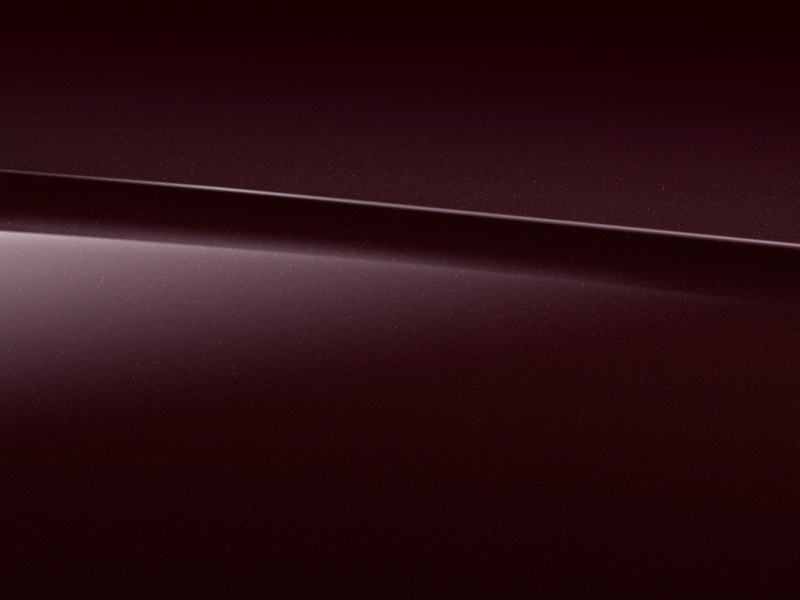 Vue de trois quarts de profil de la Mercedes Classe E Coupé avec la peinture métallisée rouge rubellite